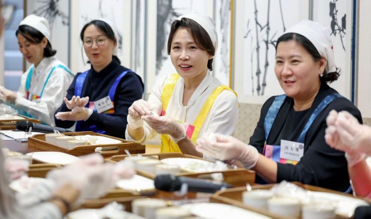 이재명 대통령과 뉴욕을 방문 중인 김혜경 여사가 23일(현지시간) 뉴욕한국문화원에서 열린 뉴욕가정상담소와 함께하는 추석맞이 송편 빚기 행사에서 참석자들과 송편을 빚고 있다. 2026.9.24 연합뉴스