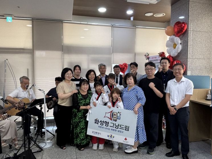 화성특례시 병점구 화산동이 지난 8월 26일 화산동주민센터에서‘화성형 그냥드림 공유냉장고 개소식을 열고 참석자들과 기념촬영을 하고 있다. 화성시 제공