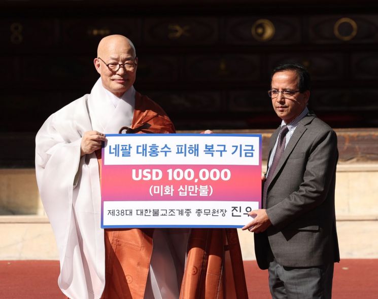 조계종 제38대 총무원장으로 취임한 진우스님이 1일 서울 종로구 조계사에서 열린 취임법회에서 니르말 프라사드 바타라이 주한네팔대사대리에게 네팔 대홍수 피해복구기금 10만 달러를 전달하고 있다. 공동취재 연합뉴스