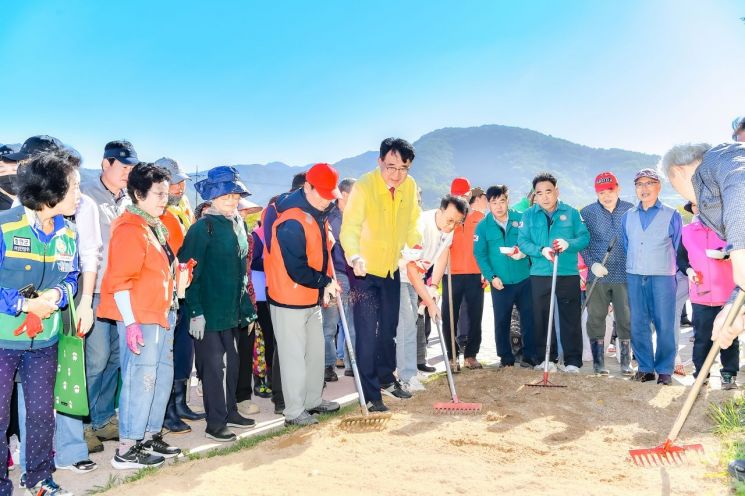 ‘아름다운 광려천 가꾸기’에 나서_행사 참석자들이 하천변에 꽃 씨앗 파종작업을 하고 있다. [사진제공=함안군]