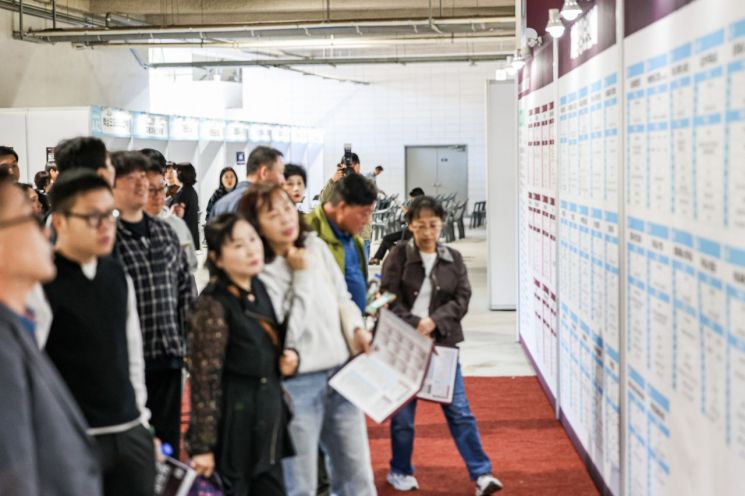 14일 용인미르스타디움에서 열린 일자리박람회에서 구직자들이 채용공고를 보고 있다. 용인시 제공