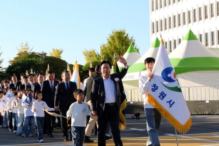 제43주년 경남도민의 날 기념식에서 강기윤 경남 창원시장을 필두로 18개 시·군 단체장과 부단체장들이 어린이의 손을 잡고 함께 입장하고 있다. [사진=이세령 기자]