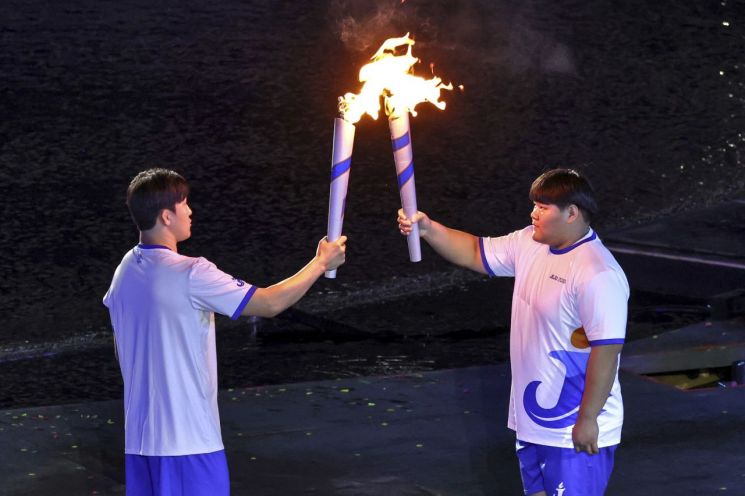 지난16일 제주월드컵경기장에서 열린 제 107회 전국체육댜회 개회식에서 성화봉송 주자들이 성화를 전달하고 있다. 화성시 제공