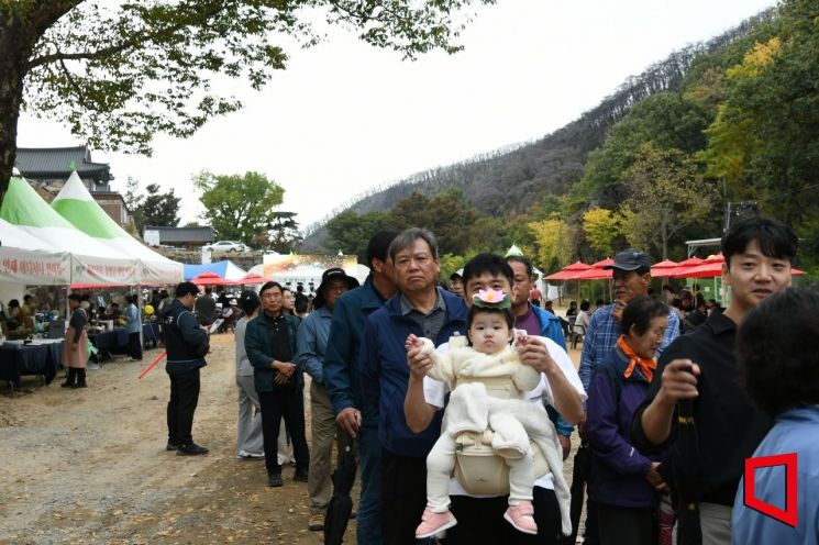 한 아이의 아버지가 아이와 함께 고운문화제·사찰음식축제 음식을 체험하기 위해 줄을 서서 기다리고 있다[사진=권병건 기자]