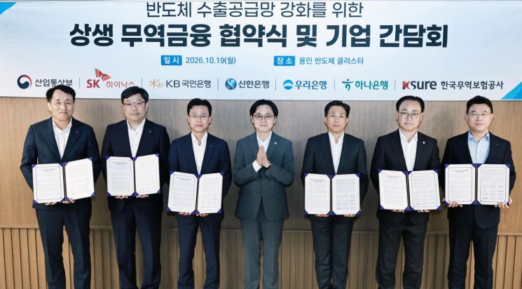19일 경기도 용인 일반산업단지에서 김정관 산업통상부 장관(가운데) 임석하에 한국무역보험공사와 SK하이닉스, 국민·신한·우리·하나은행 관계자들이 수출공급망 강화보증 업무협약을 체결한 뒤 기념촬영을 하고 있다. 산업부.