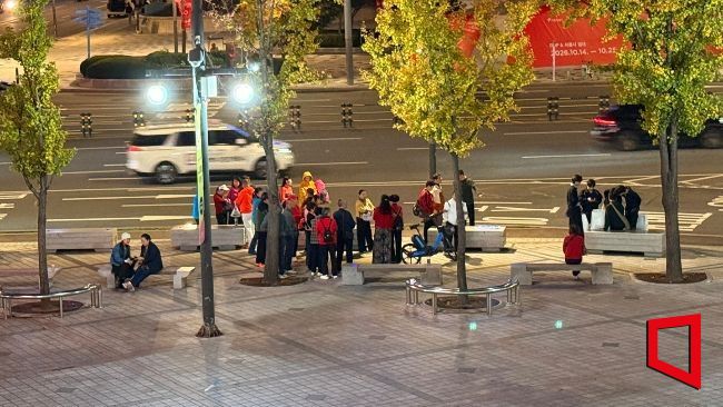 지난 14일 밤 서울 동대문 두타 앞. 한중 여행사 간 비용 정산 문제로 숙소에 가지 못한 중국인 단체관광객들이 인도에 모여 있거나 벤치에 앉아 기다리고 있다. 이들은 중국 송출업체가 미지급 운영비 2만7500위안을 송금한 뒤에야 호텔로 이동할 수 있었다. 김희윤 기자