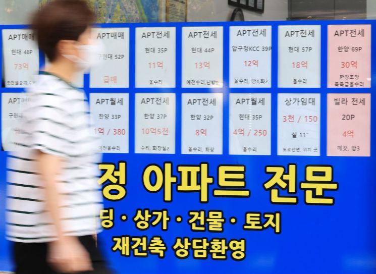 지난달 30일 한 시민이 서울 강남구 부동산에 게시된 매매 및 전세 게시물 앞을 지나고 있다. 연합뉴스