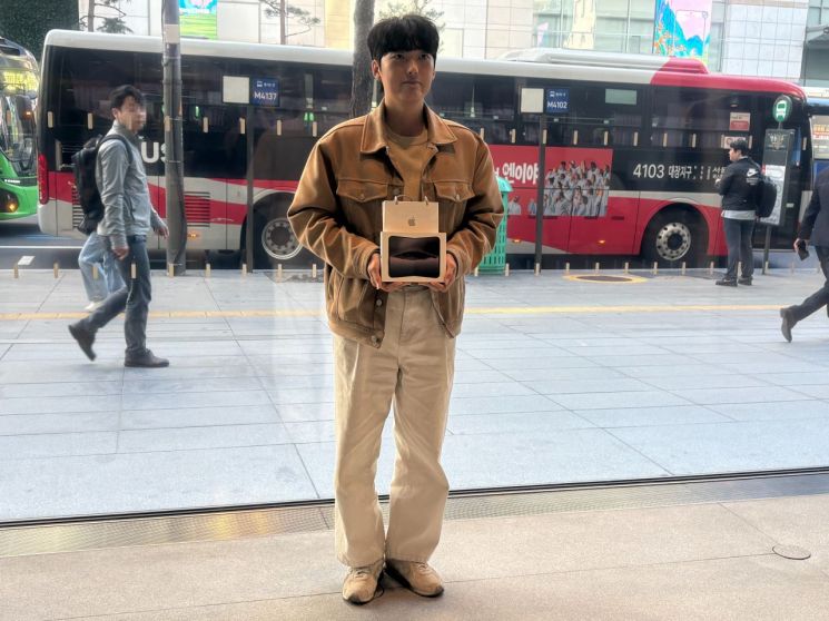 애플스토어 명동의 아이폰 듀오 1호 구매자가 된 박성건씨(33·남)씨가 제품을 들고 기념촬영을 하고 있다. 애플