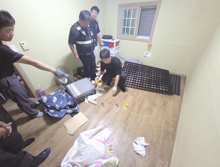 통영해양경찰이 동남아 국적 마약사범을 검거한 현장에서 범죄 관련 증거물을 압수하고 있다. [사진제공=통영해양경찰서]