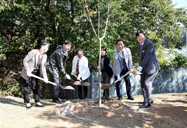 손배찬 파주시장(오른쪽)과 해외입양인들이 지난 23일 파주시 엄마품동산에서 해외에서 생을 마감한 입양인들을 추모하기 위해 ‘약속의 나무’로 이름 붙인 물푸레나무를 심고 있다. 파주시 제공