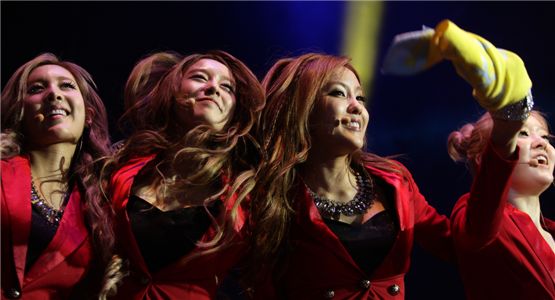 T-ara's Qri (left), Jiyeon (second to left), Hyomin (second to right) and Areum (right) smile at fans during the group's first Hong Kong showcase at the Star Hall on September 18, 2012. [Core Contents Media]