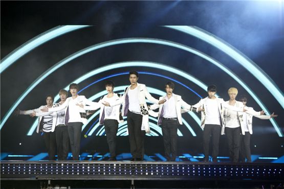 Super Junior's Kangin (left), Lee Teuk (second to left), Kyuhyun (third to left), Eunhyuk (fourth to left), Siwon (center), Donghae (fourth to right), Sungmin (third to left) and Yesung (right) open their arms while performing at "SMTOWN LIVE WORLD TOUR III in JAKARTA" opened at the Gelora Bung Karno Stadium in Jakarta, Indonesia, on September 22, 2012. [SM Entertainment]