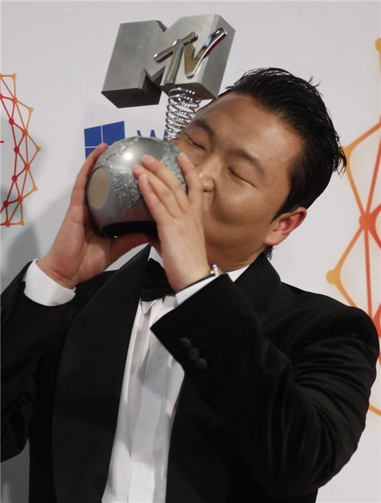 PSY kisses his Best Video award backstage during the MTV European Music Awards 2012 show at the Festhalle in Frankfurt on November 11, 2012. [REUTERS/Lisi Niesner]