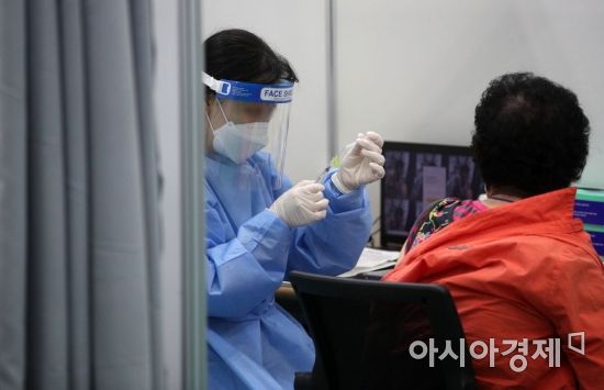 정부가 코로나19 백신 접종률을 끌어올리기 위해 '백신 접종자 인센티브' 제공 방안을 발표한 26일 서울 동대문구 예방접종센터에서 의료진이 어르신에게 백신을 접종하고 있다. 코로나19 백신 1회 접종을 마친 사람은 다음달 1일부터 직계가족모임 인원제한(현재 8명)에서 제외된다. 7월부터는 공원·등산로 등 야외에서 마스크를 벗을 수 있고 식당·카페·결혼식장 등 실내외 다중이용시설과 종교기관 출입, 사적 모임 때 정해진 인원 제한에서도 제외된다./김현민 기자 kimhyun81@