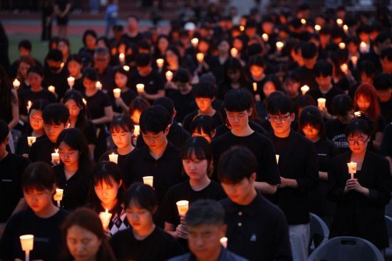 서울 서이초등학교 교사의 49재 추모일인 4일 오후 서울 서초구 서울교육대학교에서 열린 촛불문화제에서 참가자들이 묵념하고 있다.  [사진 출처=연합뉴스]