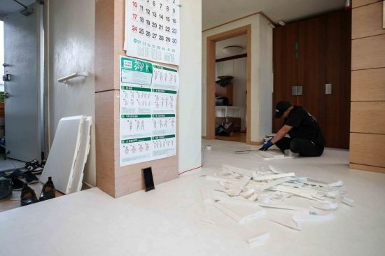 지난해 11월 18일 윤수근 할아버지와 방희연 할머니가 거주중인 서울 양천구 목동 아파트에서 인테리어 시공 관계자가 거실에 안심퍼즐매트를 시공하고 있다. 강진형 기자