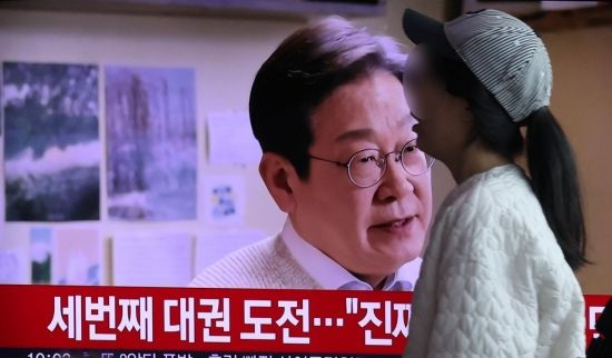 이재명 전 더불어민주당 대표가 영상 메시지를 공개하며 대선 출마를 공식 선언한 10일 서울역에서 한 시민이 영상이 중계되는 TV 앞을 지나가고 있다. 조용준 기자