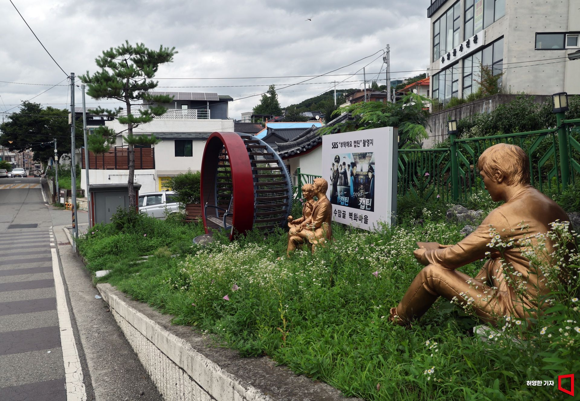 A signboard and sculptures promoting the drama filming location are installed in Suamgol Mural Village, Cheongju. Photo by Huh Younghan