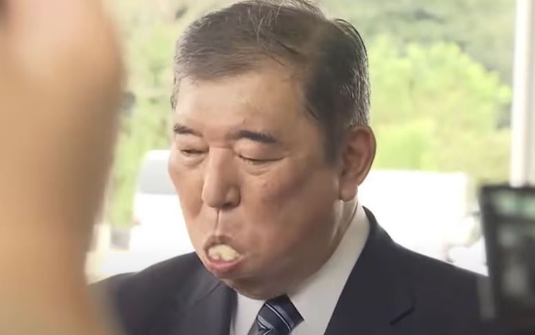 Japanese Prime Minister Shigeru Ishiba eating a meal with Japanese-style rice balls. YouTube capture