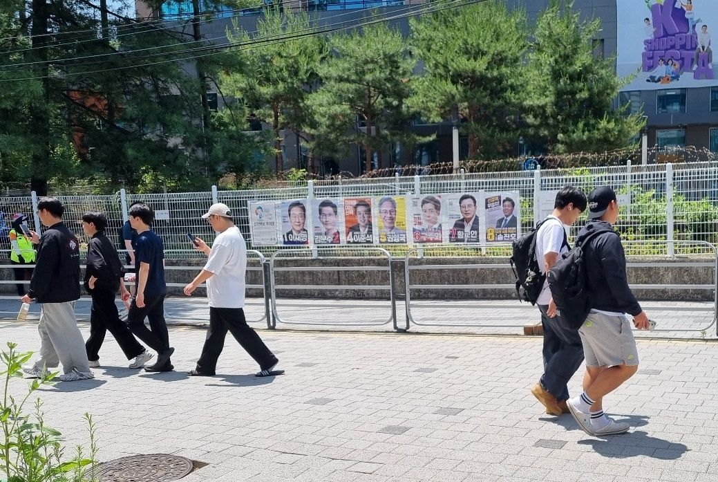 대전 충남대 앞에 붙은 21대 대선 후보들 홍보 포스터 앞을 학생들이 무심히 지나가고 있다. 대전=문혜원 기자