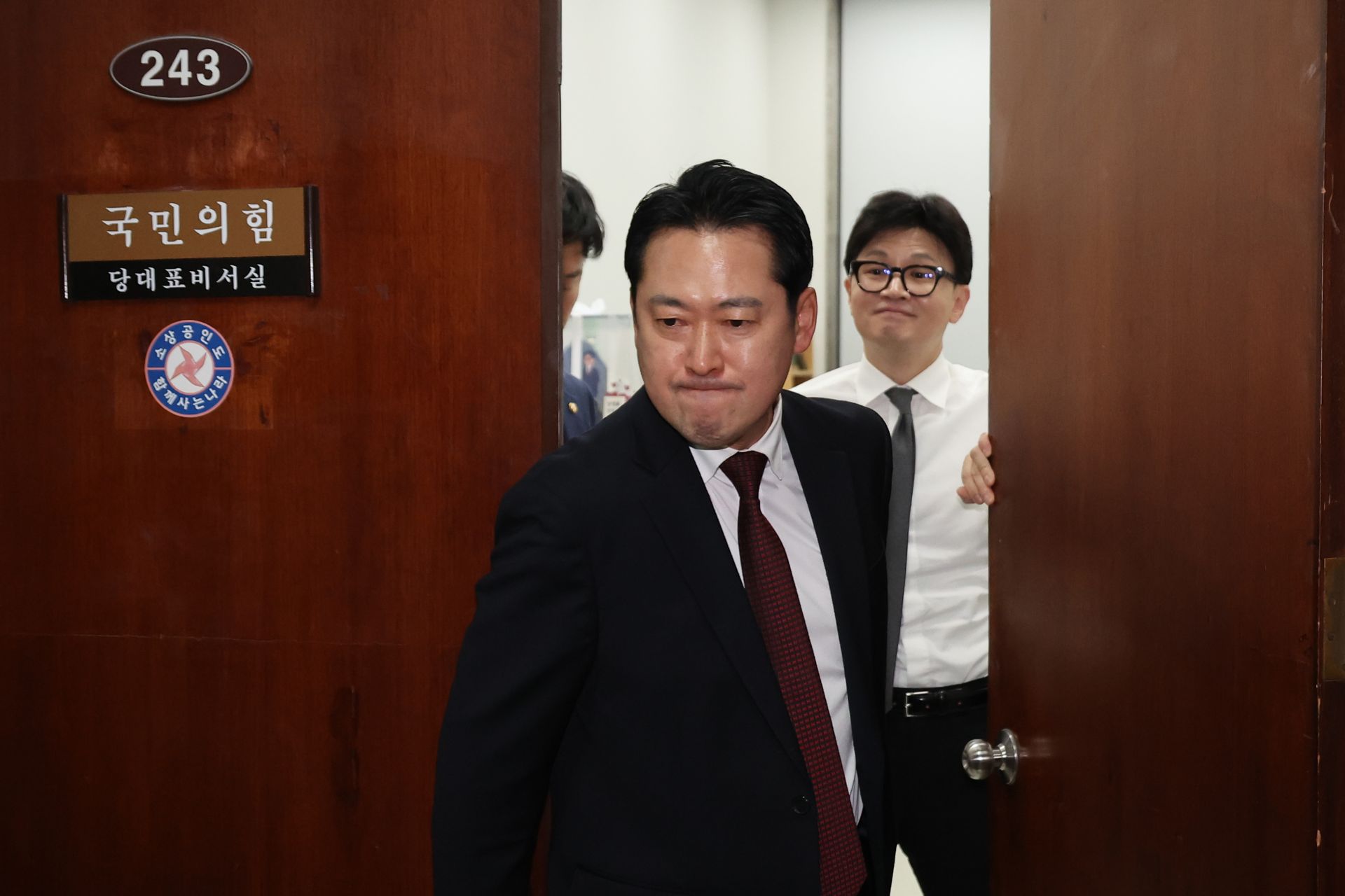 지난해 12월 11일 당시 한동훈 국민의힘 대표가 국회 당대표실에서 장동혁 의원이 나가는 사이 미소를 짓고 있다.  연합뉴스